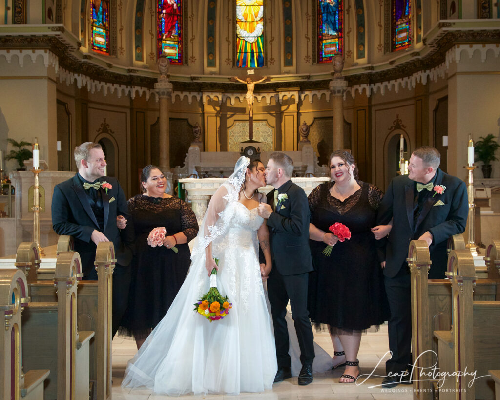 Bride and groom kissing in Catholic Church