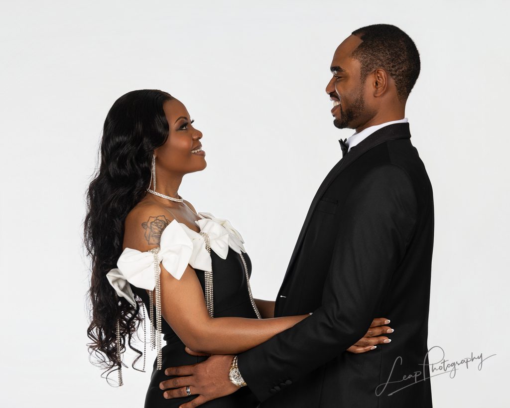 playful image of couple in formal wear photographed on a white background