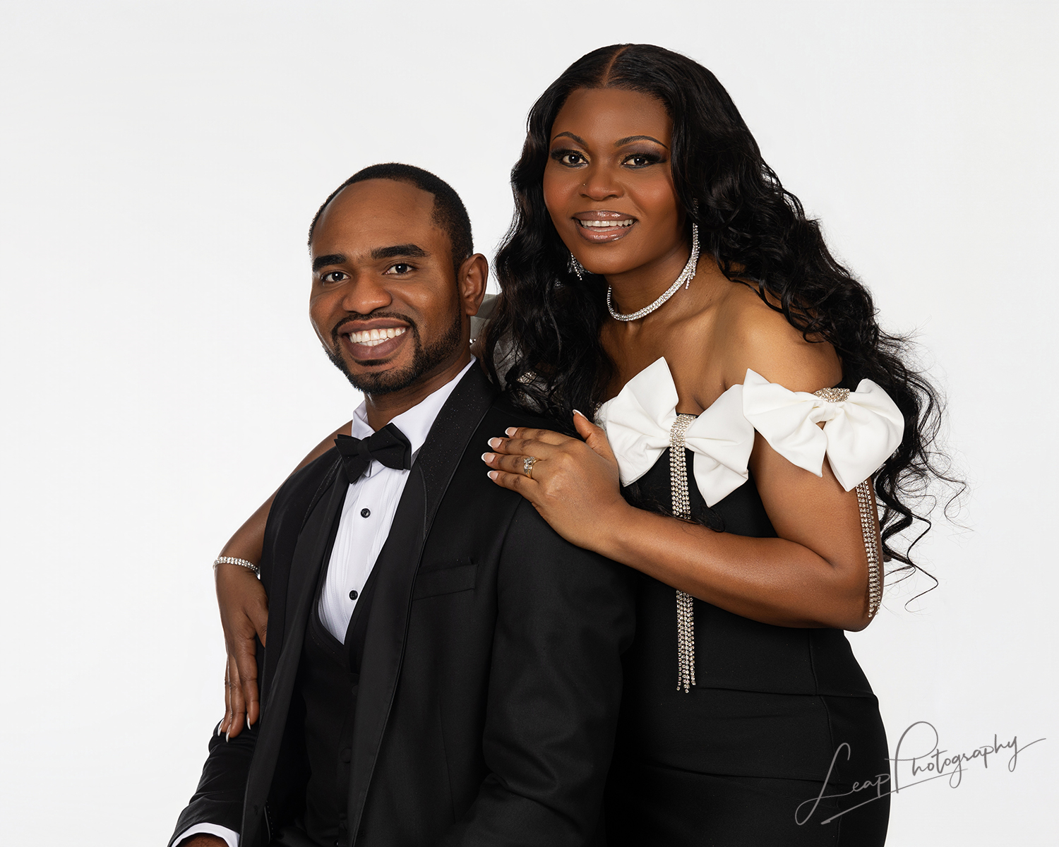Studio portrait of a couple that features a crisp white background and professional lighting